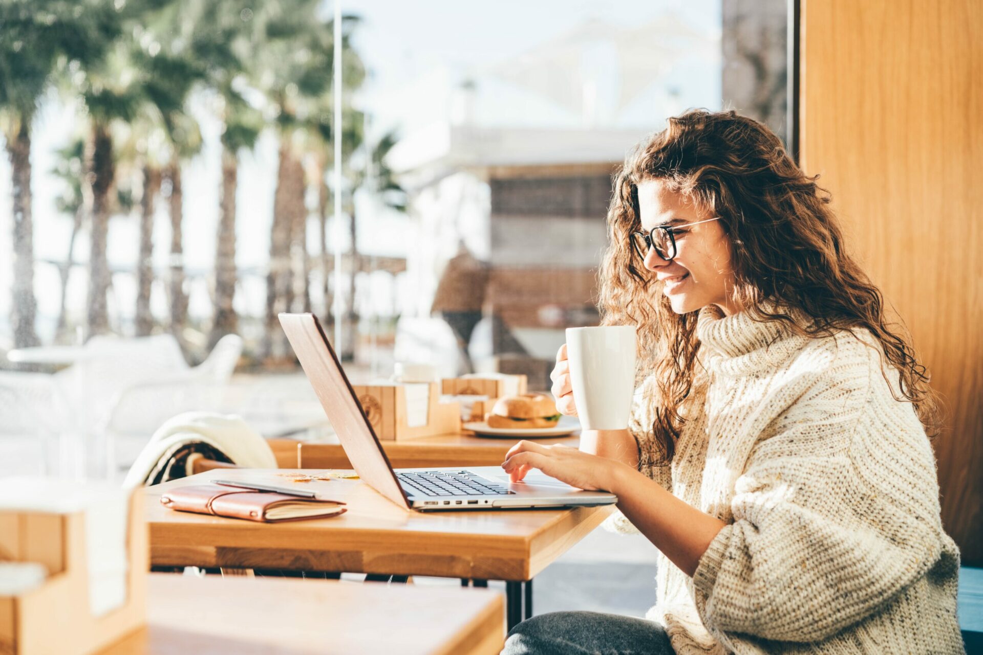 Happy woman creates a presentation based on the template in a coffee bar.