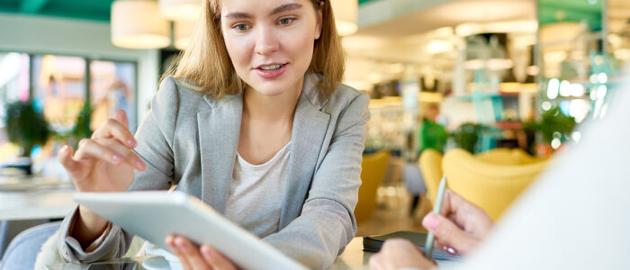 Vrouwelijke sales verantwoordelijke geeft salespresentatie aan potentiële klant via laptop